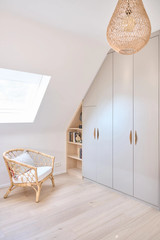 Rangement sous pente avec placard et étagères ouvertes, offrant une solution de rangement pratique dans un espace sous toit.