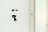 Détail d’un meuble blanc sur mesure avec boutons noirs et serrure à clé