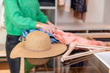 Tiroir ouvert avec accessoires et vêtements d'été dans dressing sur mesure avec séparation en bois et plateau en verre
