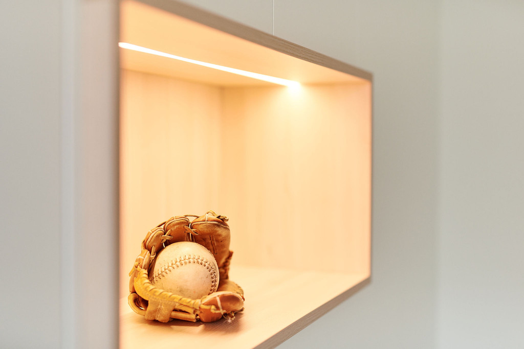 Witte wandkast met houten open nissen in de woonkamer van Yannick