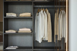 Dressing sur mesure avec penderie pour vêtements et étagères en bois foncé dans un showroom