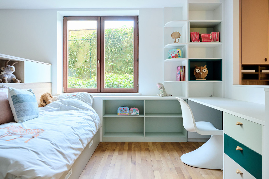 Kinderkamer met bed en bureau op maat in pasteltinten in de showroom in Sint-Pieters-Woluwe