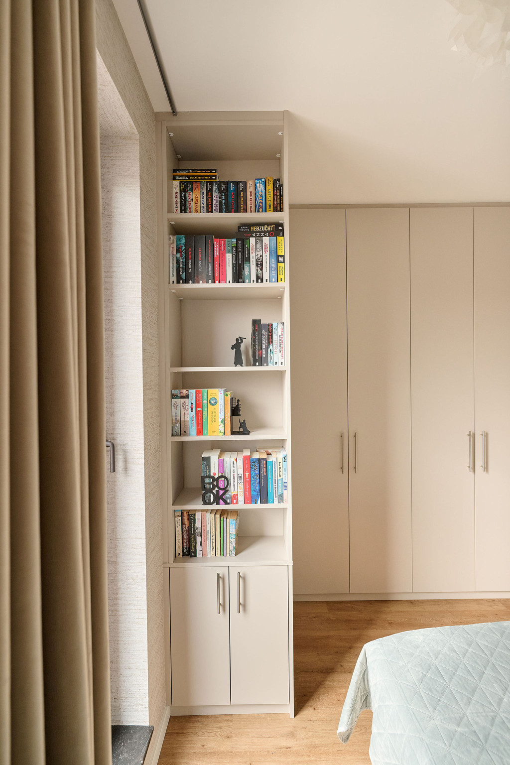 Petite bibliothèque intégrée dans un dressing sur mesure avec étagères ouvertes et rangements fermés, offrant un espace pratique et esthétique, réalisé par Camber