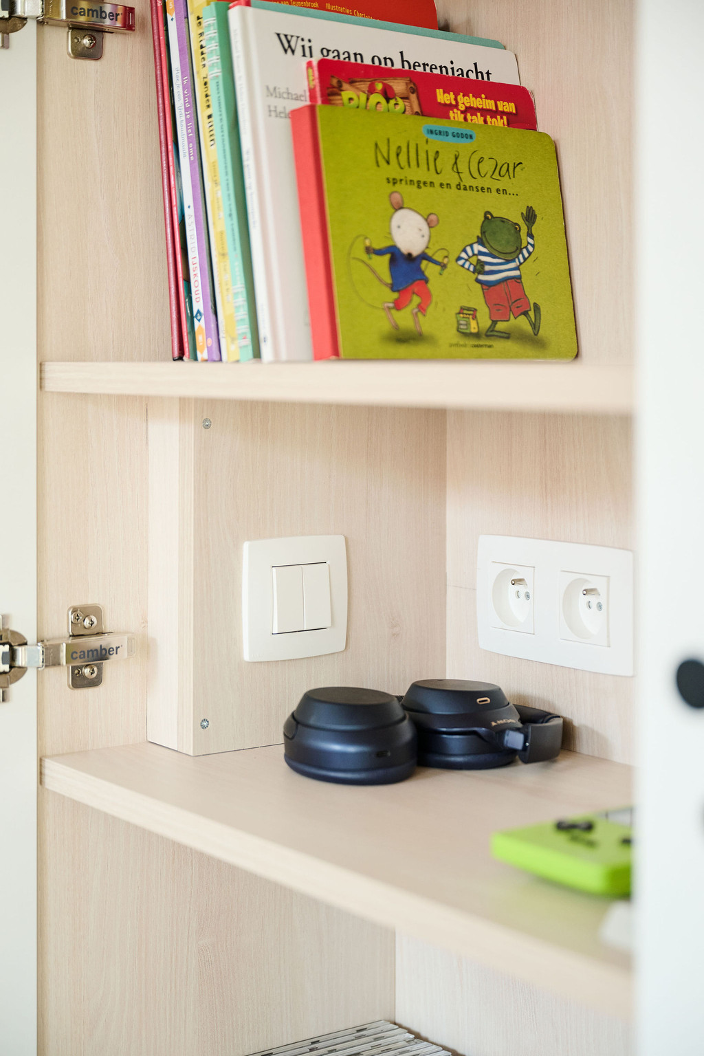 Niche ouverte avec prises intégrées et livres pour enfants dans meuble clair