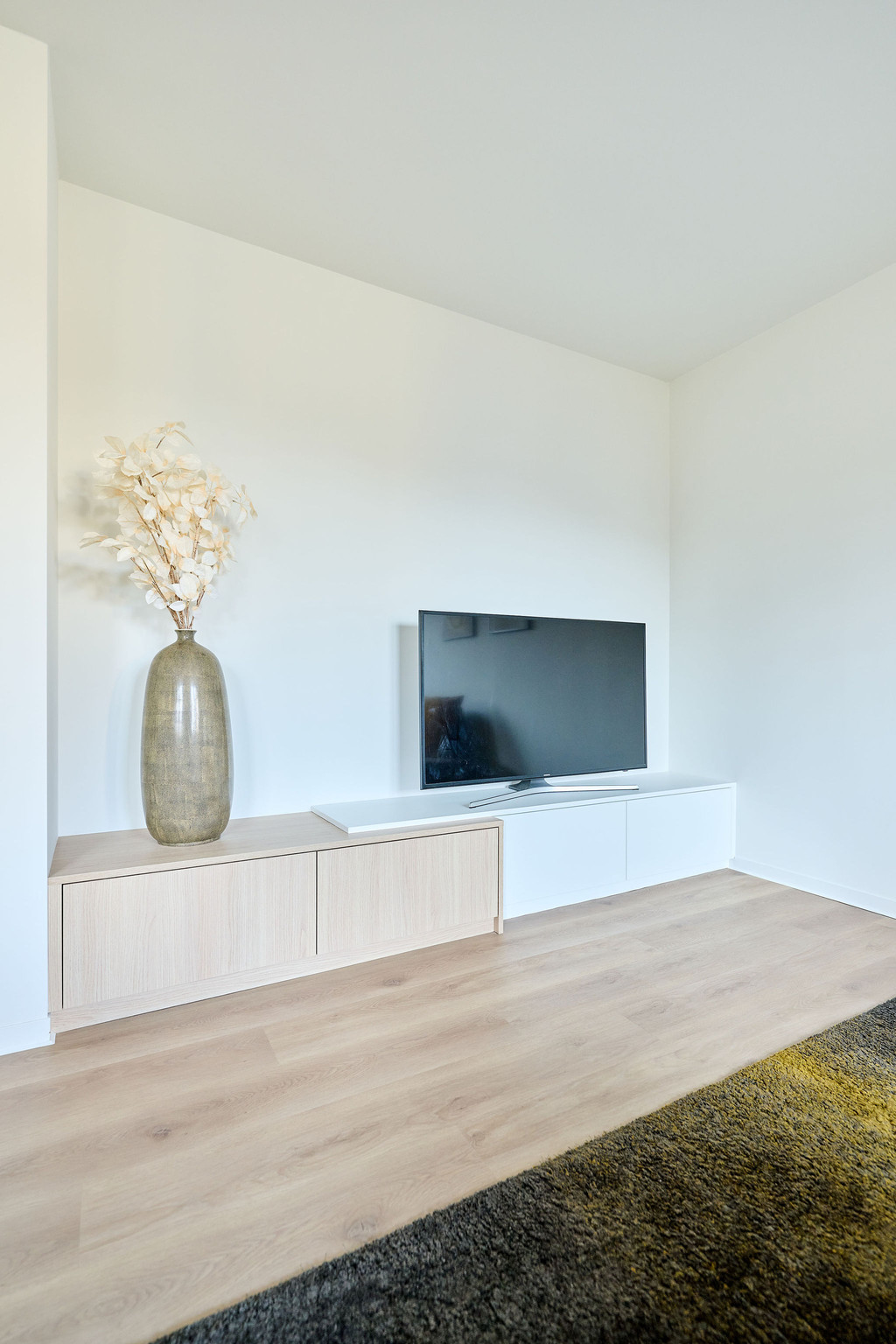 Chaleureux meuble TV sur mesure avec des touches blanches et couleur bois