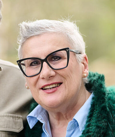 Portrait d’une cliente souriante à l’extérieur, illustrant la satisfaction après un projet d’aménagement sur mesure réalisé par Camber