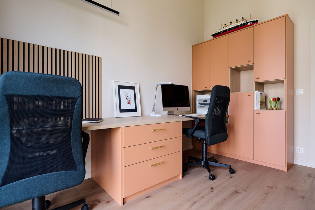 Bureau et meuble de rangement sur mesure en tons chaleureux, avec tiroirs et armoires intégrées, créant un espace de travail confortable et organisé, réalisé par Camber