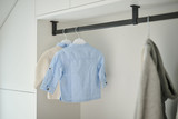 Tringle de suspension noire avec des vêtements accrochés dans une buanderie.