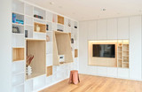 Witte bibliotheek op maat met nissen in houttint en tv-meubel