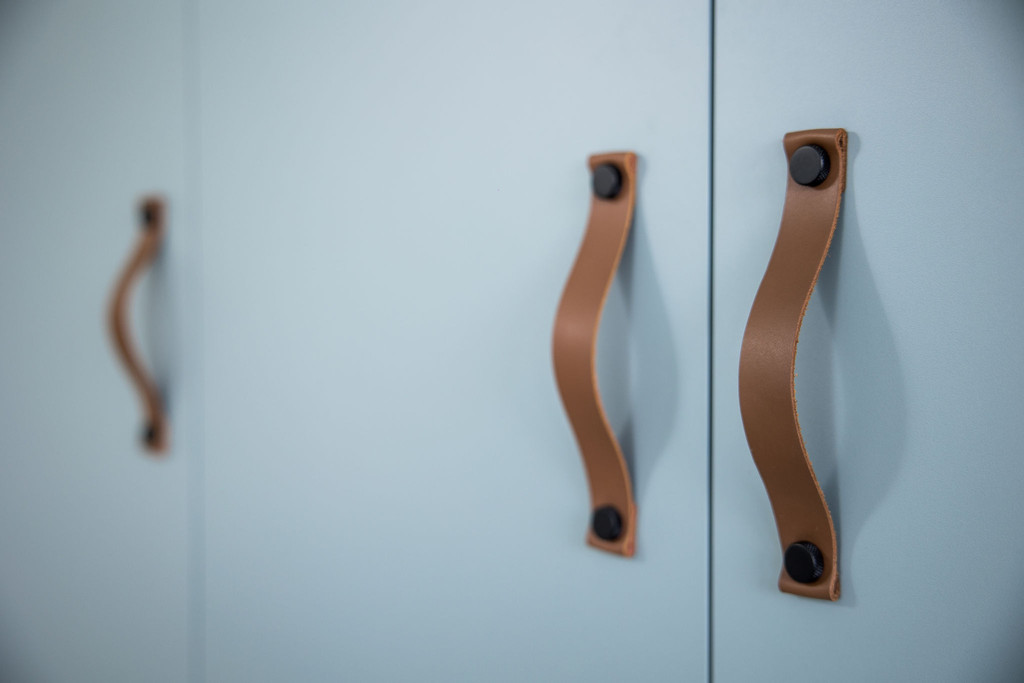 Dressing sur mesure avec poignées en cuir brun dans la chambre de Mathis à Affligem