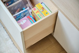 Tiroir ouvert avec des livres et bandes dessinées pour enfants dans un meuble sur mesure