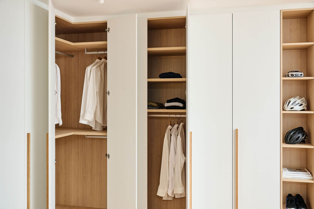 Gesloten dressing met witte deuren en interieur in houttint