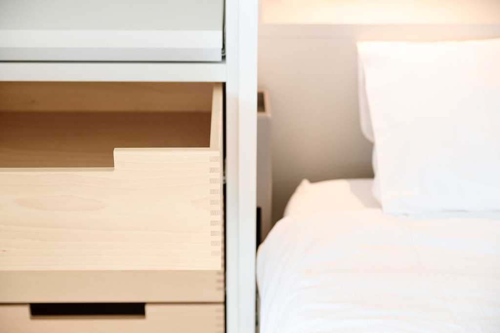 Tiroirs en bois intégrés dans la tête de lit.