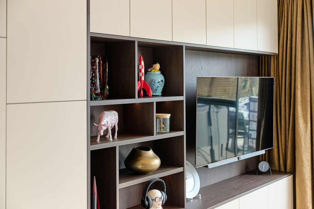 Mur TV sur mesure avec niches ouvertes en finition bois et façades épurées, permettant d’exposer des objets décoratifs dans un salon moderne, réalisé par Camber