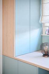 Kast in lichtblauw en hout met gesloten deuren op maat boven bureau met decoratieve lamp