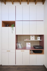 Détail d’un meuble sur mesure avec niches ouvertes, panneaux à lattes et espace de rangement pour platine et vinyles