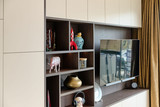 Mur TV sur mesure avec niches ouvertes en finition bois et façades épurées, permettant d’exposer des objets décoratifs dans un salon moderne, réalisé par Camber
