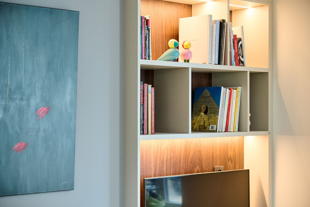 Boekenrek op maat met open vakken en verlichting in de woonkamer.