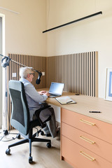 Bureau sur mesure avec plan de travail en bois, rangements intégrés et panneaux acoustiques muraux, offrant un espace de travail confortable et fonctionnel, réalisé par Camber