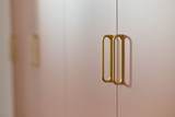 Poignées dorées sur meuble de rangement pour chambre d’enfant.