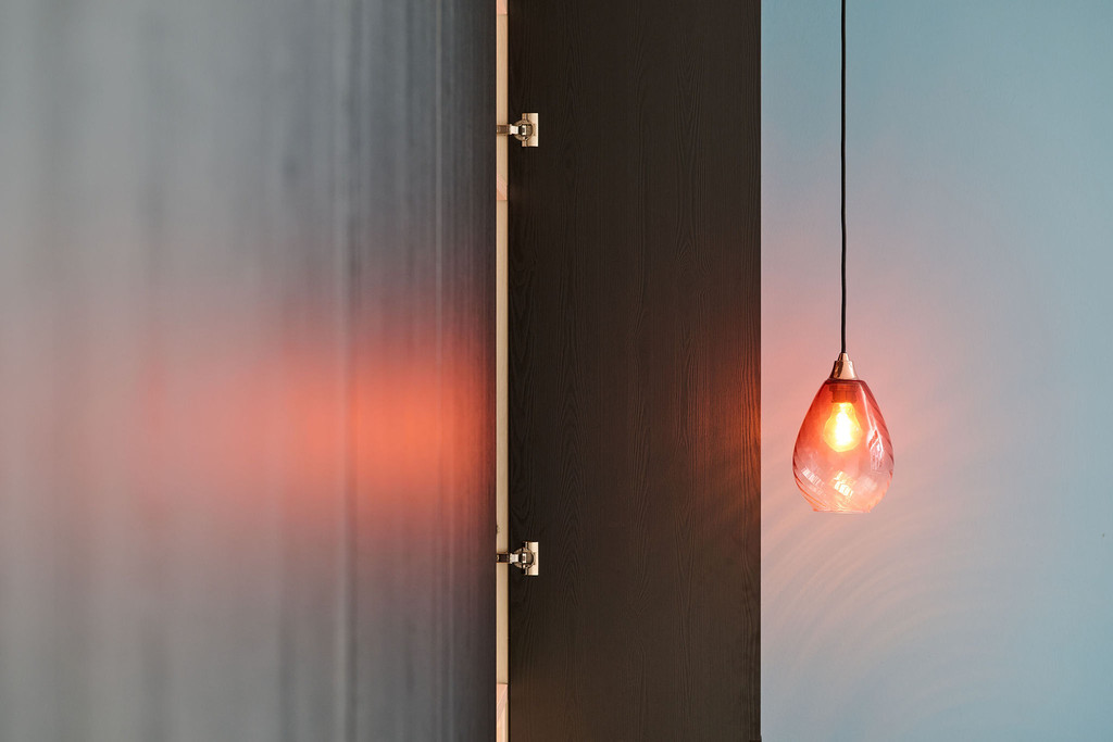 Armoire sur mesure noire avec portes battantes et éclairage d’ambiance