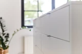 Détail d’un îlot de dressing blanc avec poignées modernes et fines pour une finition épurée