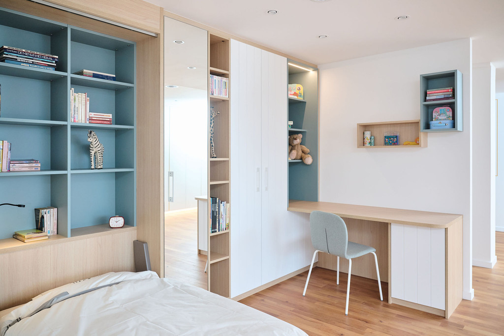 Chambre d'enfant blanc et bleu sur mesure avec bureau intégré à une étagère et une garde robe à Dilbeek