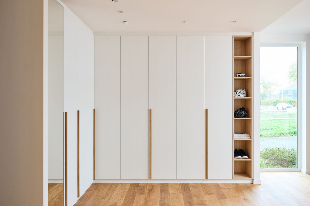 Dressing sur mesure avec portes blanches et niches ouvertes sur les côtés pour un rangement pratique.