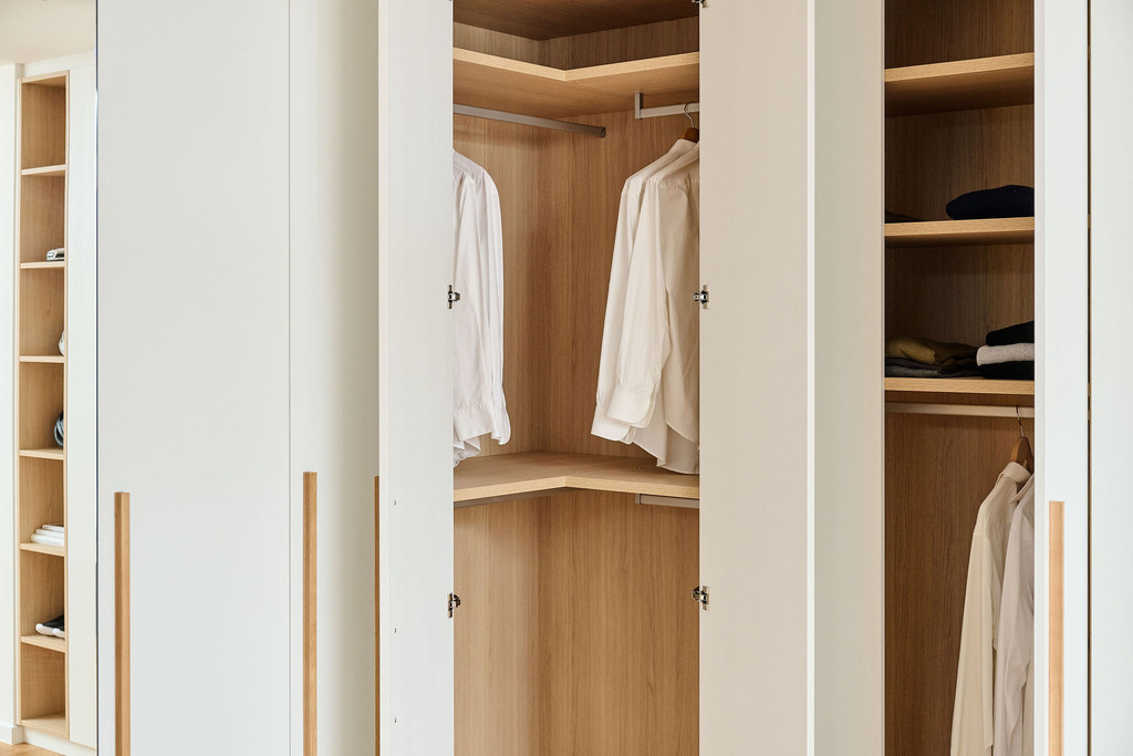 Dressing en L sur mesure avec penderie d'angle offrant un rangement spacieux et pratique pour les vêtements.