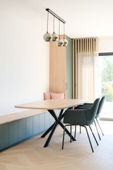 Coin repas lumineux avec banquette verte sur mesure et table en bois clair