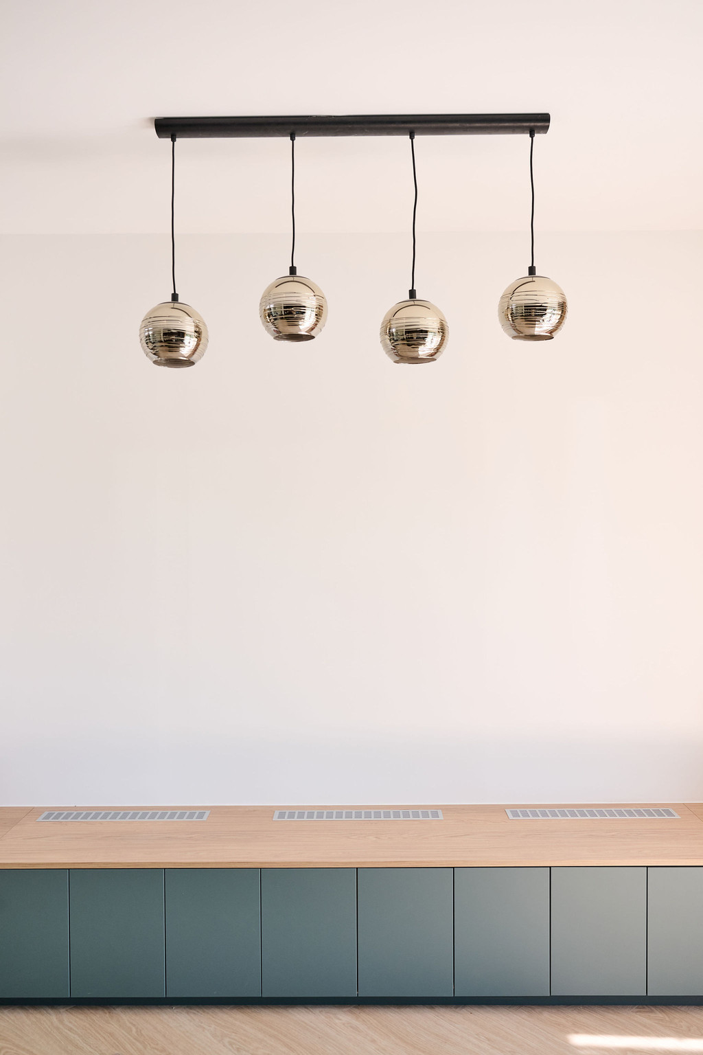 Suspension design au-dessus d’une banquette sur mesure en bois clair