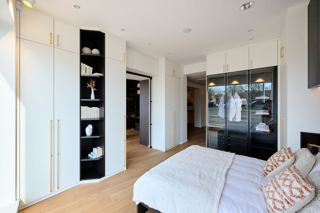 Chambre à coucher avec armoires fermées blanches et niches ouvertes noires pour la décoration