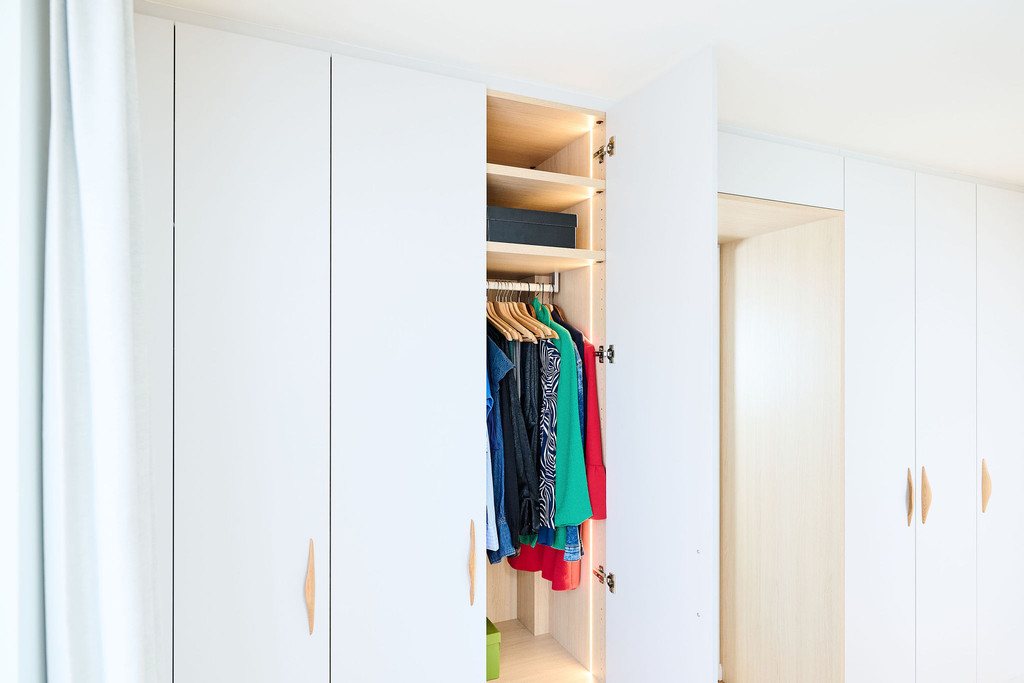 Placard sur mesure avec penderie pour vêtements et éclairage LED intégré dans une chambre lumineuse