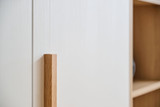 Dressing en L sur mesure avec poignée en bois pour une finition élégante et moderne.