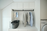 Meuble de buanderie sur mesure avec tringle à vêtements et panier pour le linge.