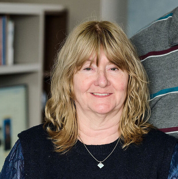 Portrait d’une cliente souriante à l’intérieur, illustrant la satisfaction après un projet d’aménagement sur mesure réalisé par Camber