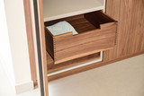 Houten lade in een op maat gemaakte vestiairekast, open getrokken voor extra opbergruimte.
