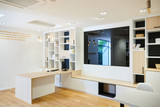 Combinaison d'un meuble TV et bureau intégré à une bibliothèque en U de couleur blanc et bois naturel à Laethem-Saint-Martin