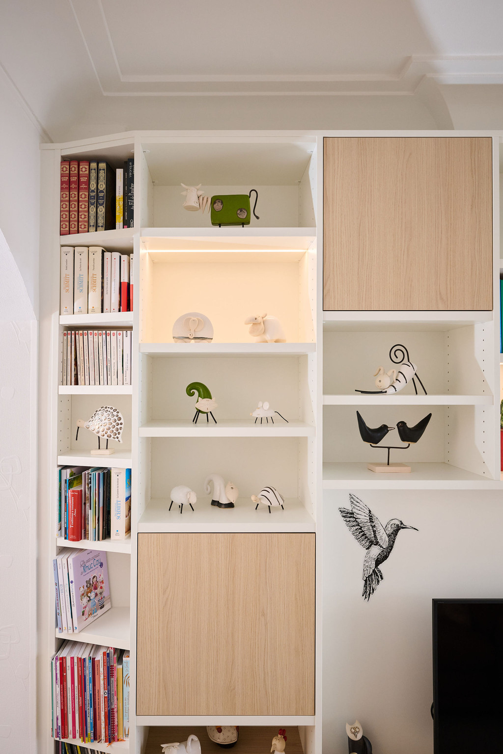 Détail d’un meuble TV sur mesure avec niches ouvertes et objets décoratifs