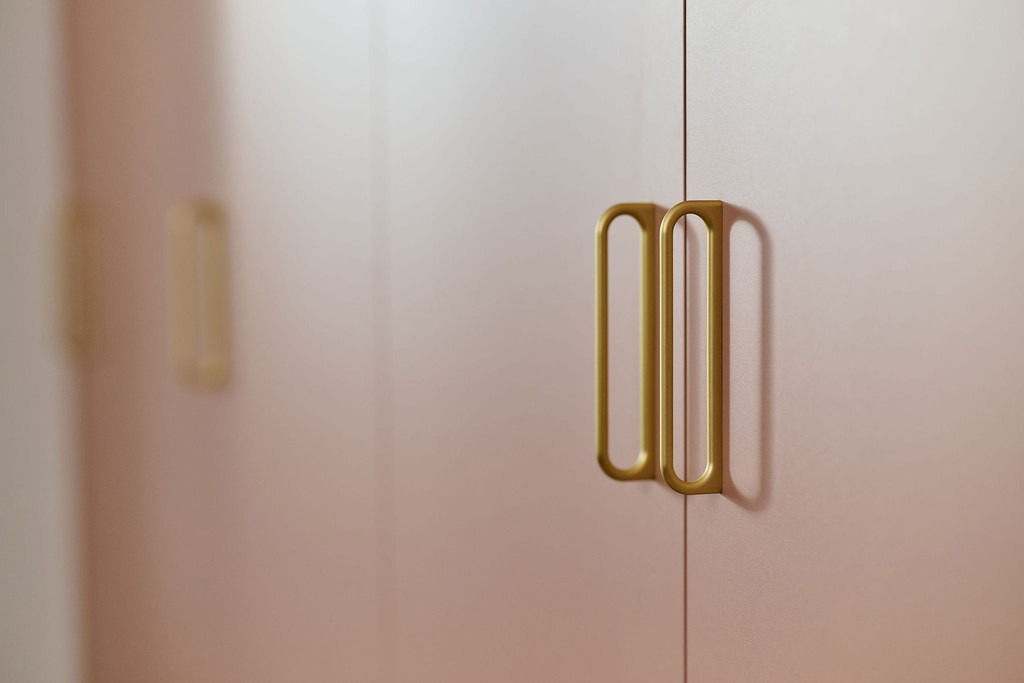 Poignées dorées sur meuble de rangement pour chambre d’enfant.