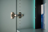 Close-up van scharnier in blauw maatwerkkastje met verstelbare legplanken en turquoise boeken