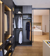 Dressing d’angle sur mesure avec penderie, niches ouvertes et éclairage LED intégré en showroom