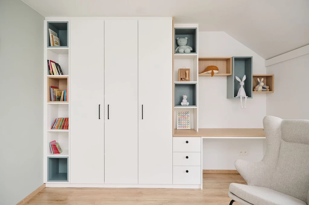 Chambre d'enfant sur mesure avec bibliothèque, rangement, et coin bureau intégré, décoré de jouets.