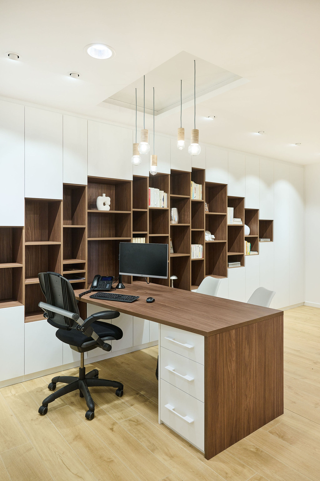 Bibliothèque blanche et bois foncé avec bureau intégré sur mesure avec placards et niches ouvertes à Wavre