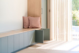 Banquette sur mesure verte avec rangements ouverts et coussins roses