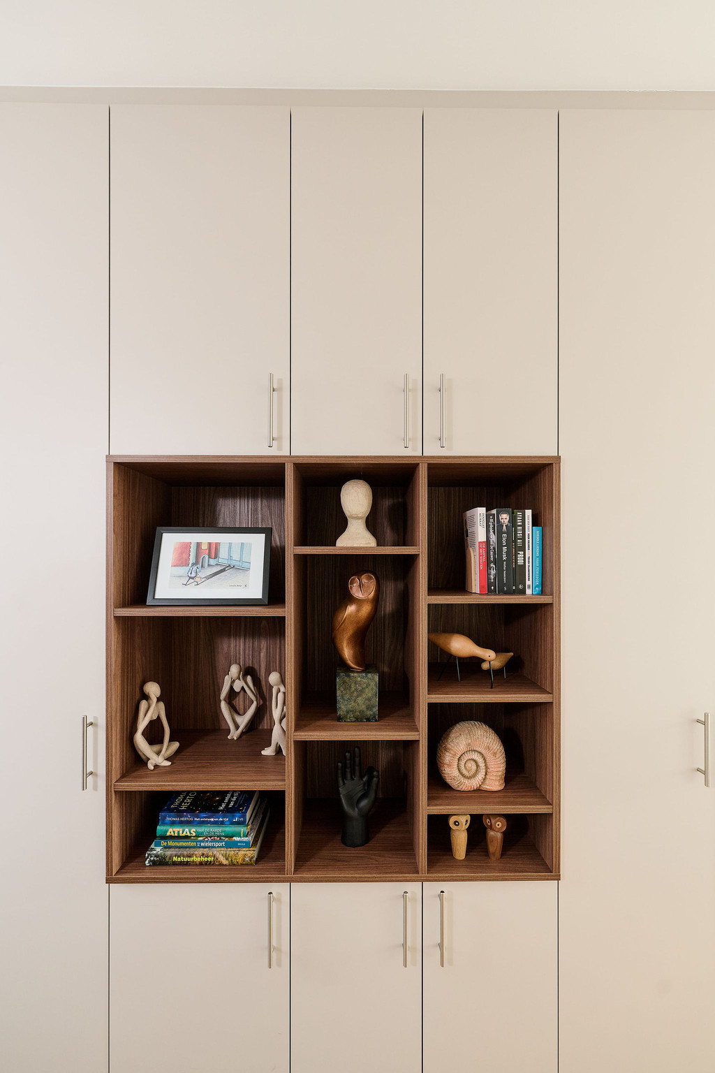 Placard sur mesure avec niches ouvertes en finition bois pour exposer des objets décoratifs, combiné à des rangements fermés pour un intérieur harmonieux, réalisé par Camber