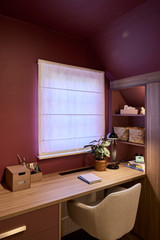 Bureau op maat met lades en open vakken onder een raam in een warme slaapkamer