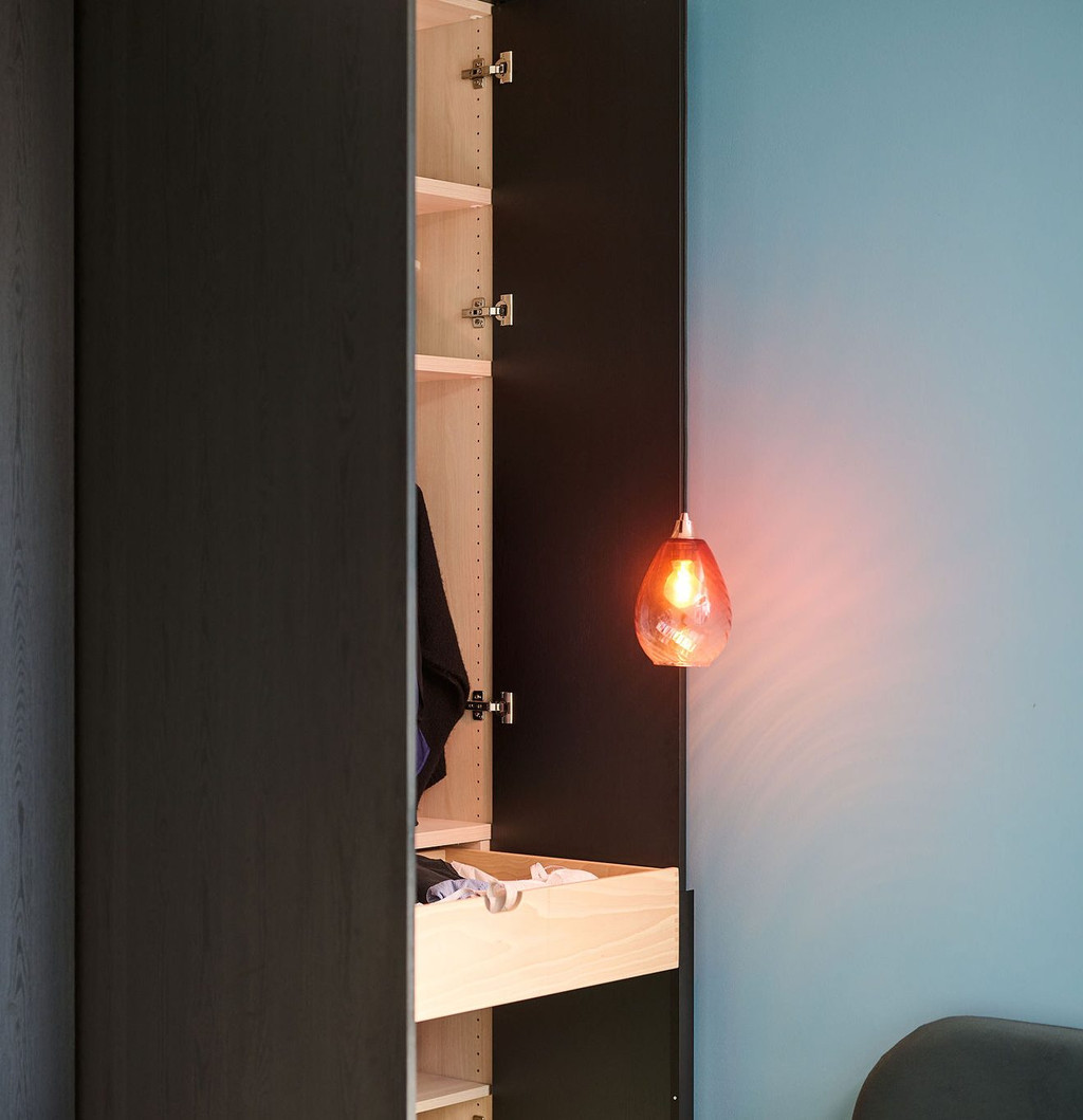 Dressing sur mesure en bois foncé avec tiroirs coulissants et étagères ouvertes