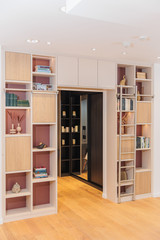 Bibliothèque sur mesure en pont avec niches ouvertes et étagères dans les tons bois et terracotta à Hasselt