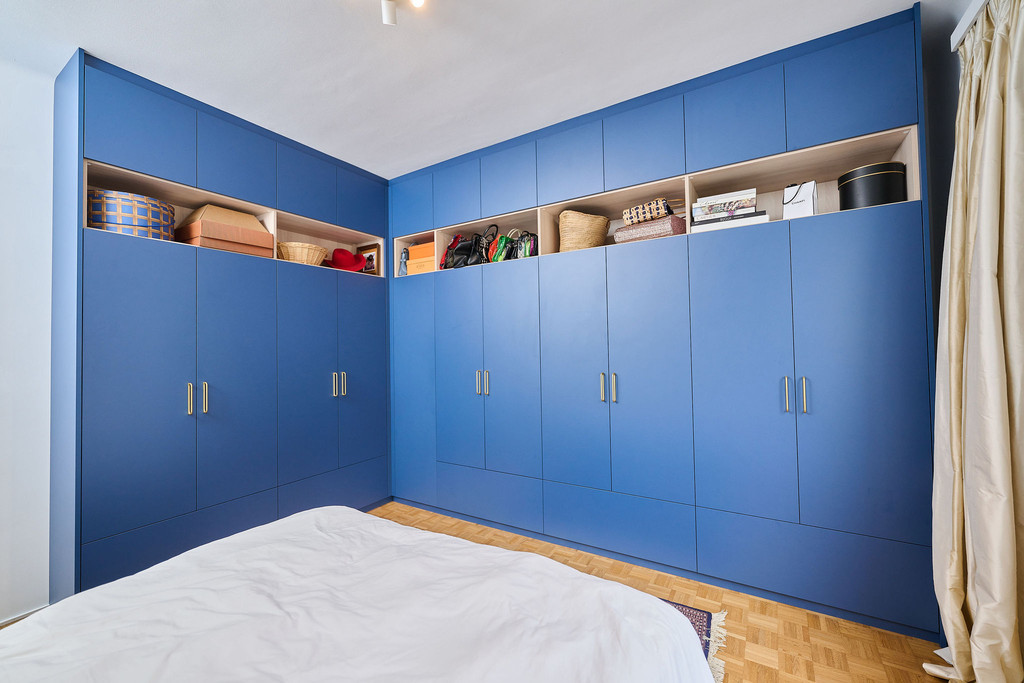 dressing bleu avec poignées dorées et niches ouvertes en teinte de bois
